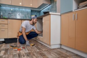 young-caucasian-repairman-installing-kitchen-furni-2022-02-22-05-13-12-utc-1-scaled